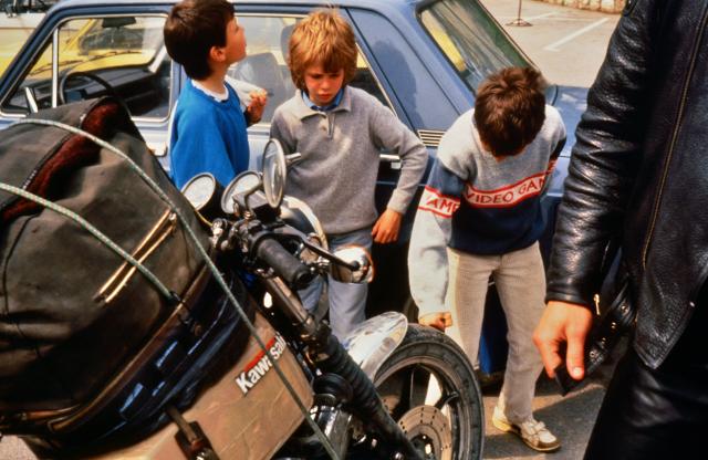 Kinder in Ungarn bestaunen das fremde vollgepackte Motorrad