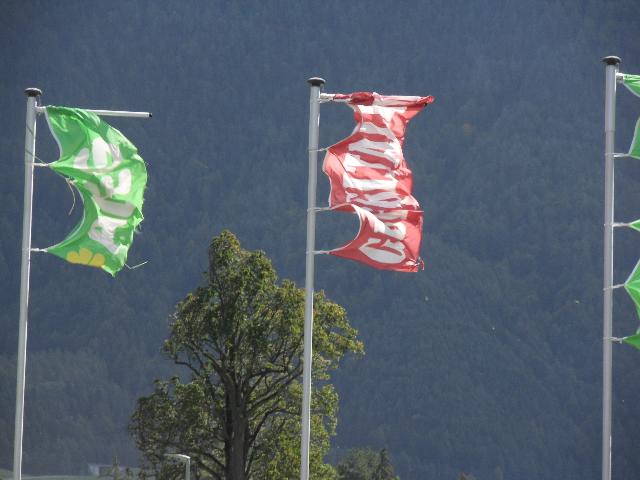Fahnen im Wind vor dem Supermarkt in Nassereith